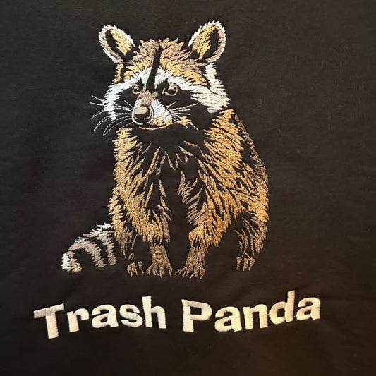 Photoreal raccoon embroidered in metallic-toned thread above the words Trash Panda on a black t-shirt by Raging Thunder Apparel
