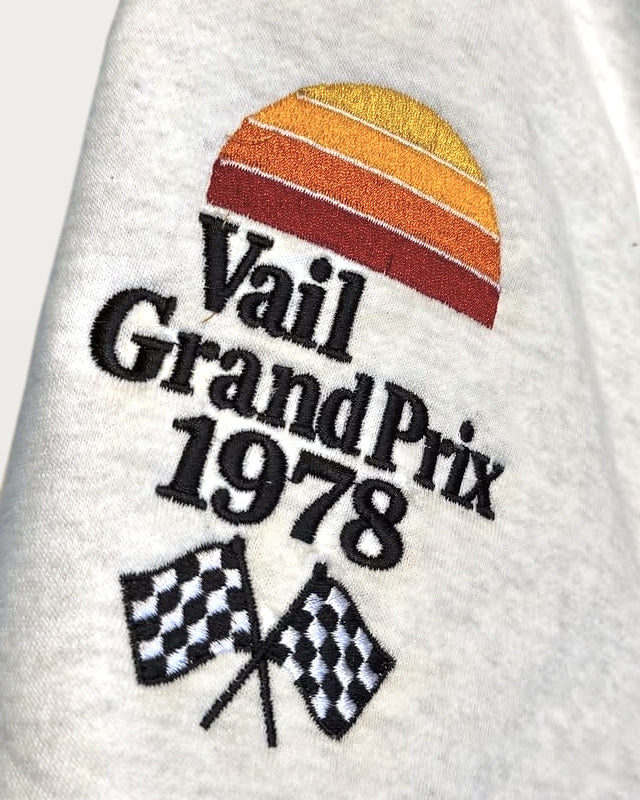 Actual Vail Grand Prix 1978 front embroidery — retouched photograph of the original sunset, lettering and crossed checkered flags.